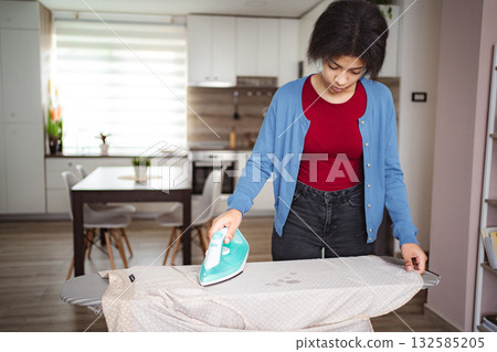 Young Woman Ironing Clothes at Home Young Woman Ironing Clothes at Home 132585205