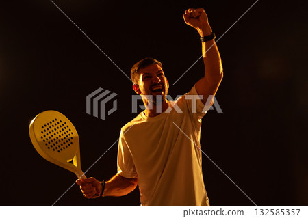 Celebration of victory in a sports match with a paddle in hand during evening practice 132585357