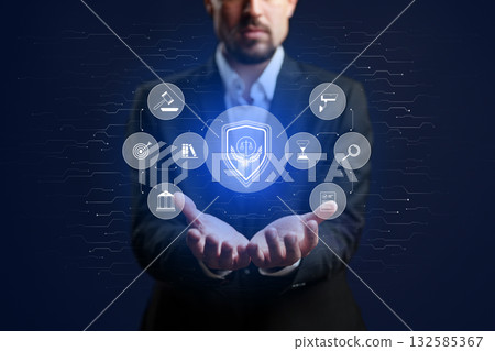 Man in suit holds glowing shield with legal icons in hands, representing protection and justice 132585367