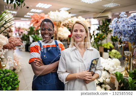 Two Smiling Florists Posing in Flower Shop with Digital Tablet Two Smiling Florists Posing in Flower Shop with Digital Tablet 132585502