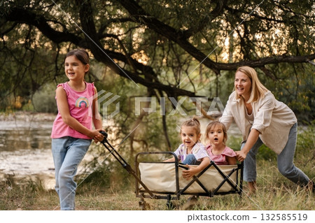 Happy family playing together in the park near the river 132585519