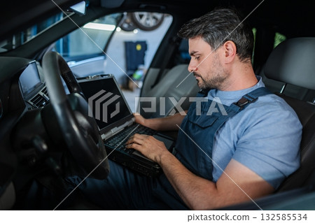 Mechanic using a laptop to diagnose a car's problems 132585534