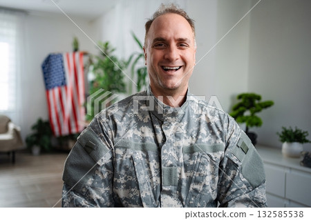 Happy American Soldier Smiling at Home with United States Flag Happy American Soldier Smiling at Home with United States Flag 132585538