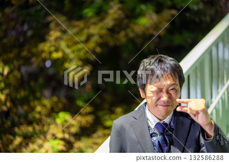 一位商人比劃著，表示他離成功只差一步之遙。 132586288