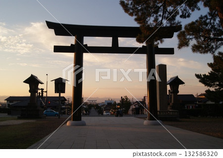 The silhouette of the large torii gate and lantern stands out against the morning glow The silhouette of the large torii gate and lantern stands out against the morning glow 132586320