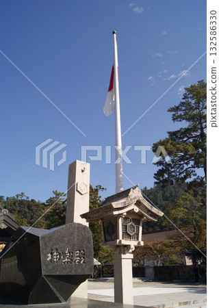 巨大的鳥居上飄揚著日本國旗,那是神社的入口。 巨大的鳥居上飄揚著日本國旗,那是神社的入口。 132586330