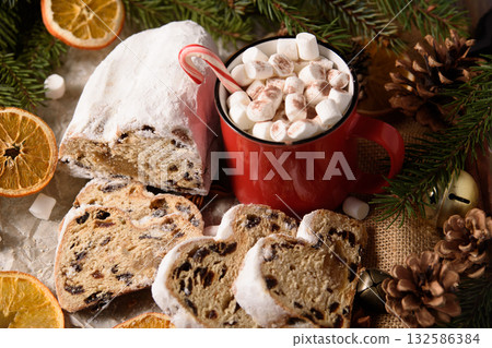 Christmas stollen on wooden background. Traditional christmas german dessert cut into pieces. Cake with nuts, raisins with marzipan and dried fruit on cutting board. baking for xmas Christmas stollen on wooden background. Traditional christmas german dessert cut into pieces. Cake with nuts, raisins with marzipan and dried fruit on cutting board. baking for xmas 132586384