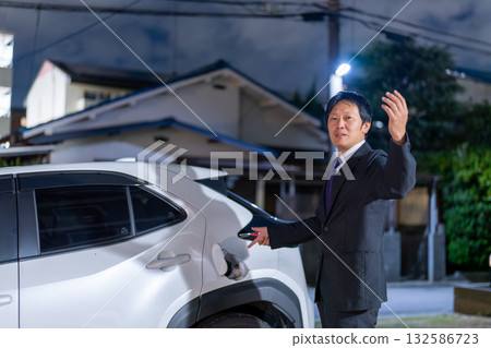 A businessman's gesture to guide the location of a refueling station A businessman's gesture to guide the location of a refueling station 132586723