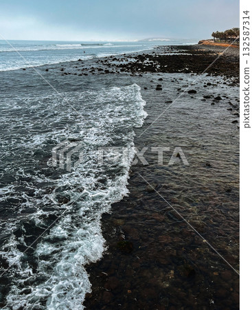 Waves washing over rocky 132587314