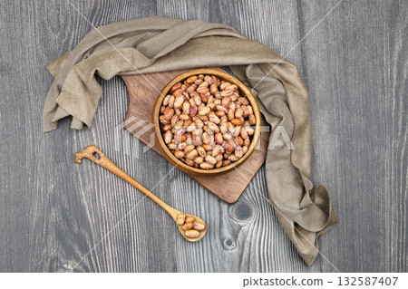 red kidney beans in wooden bowl isolated on dark background. red kidney beans in wooden bowl isolated on dark background. 132587407