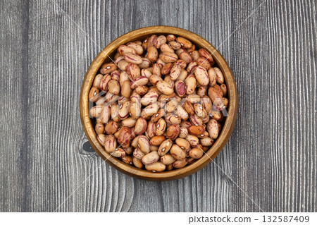 red kidney beans in wooden bowl isolated on dark background. red kidney beans in wooden bowl isolated on dark background. 132587409