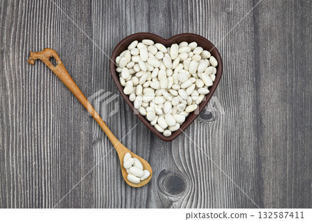 white kidney beans in a heart shaped bowl a on wooden background.Top view. white kidney beans in a heart shaped bowl a on wooden background.Top view. 132587411