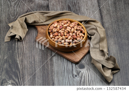 red kidney beans in wooden bowl isolated on dark background. red kidney beans in wooden bowl isolated on dark background. 132587434