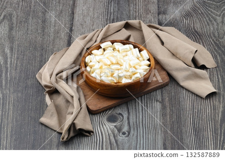 White sugar in a wooden bowl on a wooden background. Ramadan Feast candy. White sugar in a wooden bowl on a wooden background. Ramadan Feast candy. 132587889