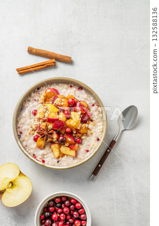 Overnight oatmeal with apple, cranberry and cinnamon in a bowl on a light background Overnight oatmeal with apple, cranberry and cinnamon in a bowl on a light background 132588136