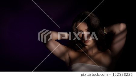 Young woman posing with striped shadows on purple background Young woman posing with striped shadows on purple background 132588225