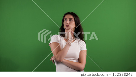 Young woman is thinking with hand on chin on green screen background 132588242