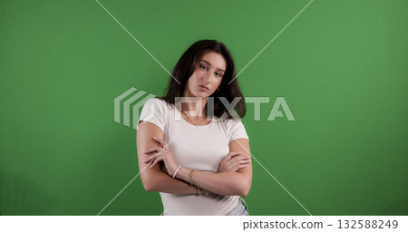 Young woman crossing arms showing confidence on green screen background Young woman crossing arms showing confidence on green screen background 132588249