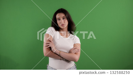 Young woman crossing arms with confident expression on green screen background Young woman crossing arms with confident expression on green screen background 132588250