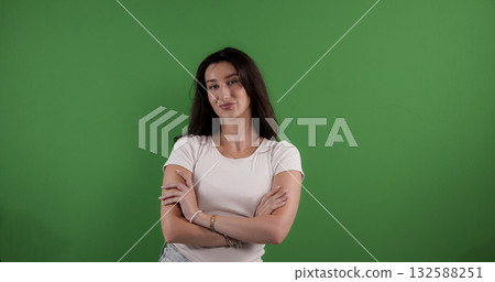 Confident young woman crossing arms on green screen background Confident young woman crossing arms on green screen background 132588251