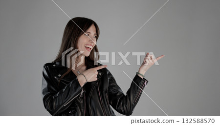 Young woman pointing with fingers to the side, showing and presenting something interesting Young woman pointing with fingers to the side, showing and presenting something interesting 132588570
