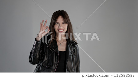 Musician showing ok sign and smiling on gray background Musician showing ok sign and smiling on gray background 132588582