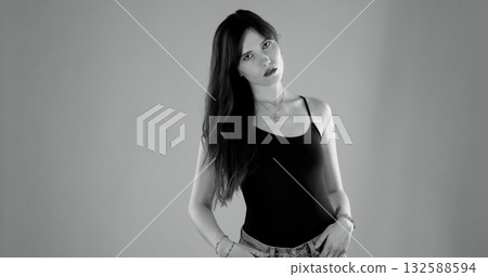 Young woman posing with hands in pockets, black and white portrait Young woman posing with hands in pockets, black and white portrait 132588594