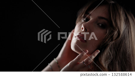 Studio portrait of beautiful model posing with hands on her face and neck 132588614