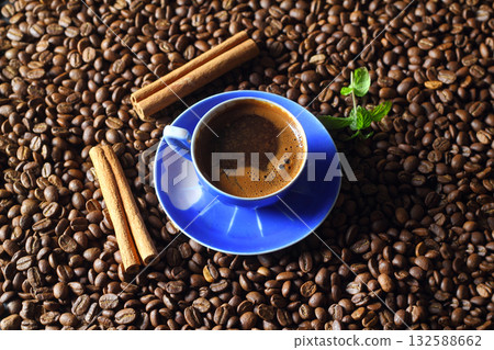 Cup of coffee with coffee beans and cinnamon sticks Cup of coffee with coffee beans and cinnamon sticks 132588662
