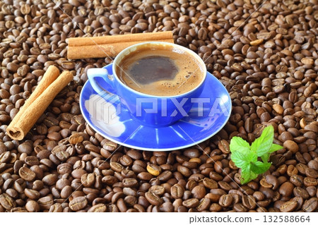 Cup of coffee with coffee beans and cinnamon sticks Cup of coffee with coffee beans and cinnamon sticks 132588664