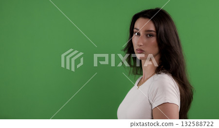 Young woman posing on green screen background looking serious 132588722