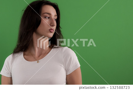 Young woman looking away on green screen background Young woman looking away on green screen background 132588723
