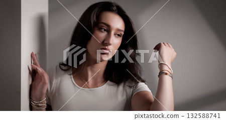 Young woman posing and touching her hair in studio with white background Young woman posing and touching her hair in studio with white background 132588741