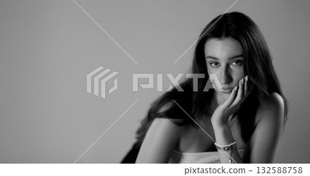 Young woman posing with hand on face in black and white Young woman posing with hand on face in black and white 132588758