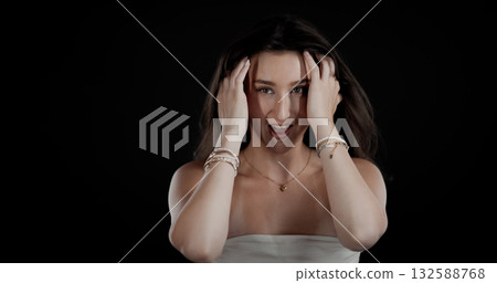Excited young woman holding her head with hands and screaming on black background Excited young woman holding her head with hands and screaming on black background 132588768