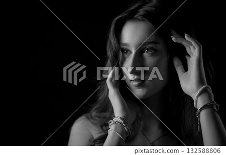 Young Woman Touching Hair and Looking Away in Black and White Portrait 132588806