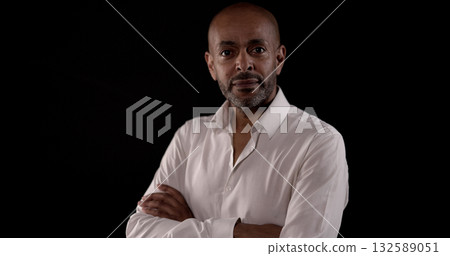 Confident businessman crossing arms on black background 132589051