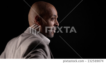Confident african american businessman looking forward on dark background 132589074