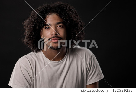 Portrait of Young African American Man with curly Hair Posing on Black Background 132589253