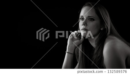 Pensive young woman holding her face and thinking in black and white 132589376