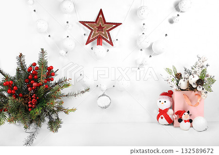 Empty table with a bouquet of live Christmas trees in a vase, with gifts, decorations and a snowman on an elegant background with a star. Christmas and New Year eco layout for design Empty table with a bouquet of live Christmas trees in a vase, with gifts, decorations and a snowman on an elegant background with a star. Christmas and New Year eco layout for design 132589672