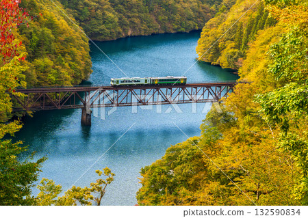 Autumn leaves blooming in the mountains and a locomotive crossing the Tadami River Third Bridge Autumn leaves blooming in the mountains and a locomotive crossing the Tadami River Third Bridge 132590834