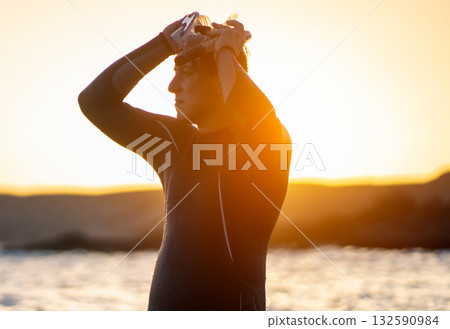 A man is preparing for diving in the ocean at sunset. 132590984