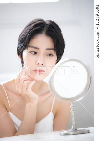 特寫鏡頭：一位女士對著鏡子，擔憂自己的皮膚問題。 132591081