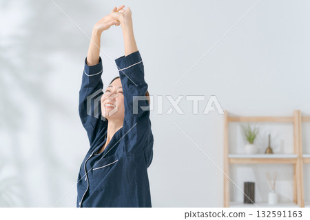 A woman who wakes up in the morning and stretches 132591163