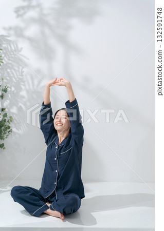 一個穿著睡衣的女人伸懶腰 132591748