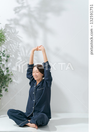 一個穿著睡衣的女人伸懶腰 一個穿著睡衣的女人伸懶腰 132591751