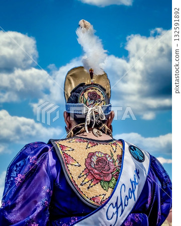 Traditional attire with feathered headdress against blue sky 132591892