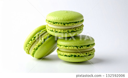 A stack of three vibrant green pistachio or matcha macarons on a white background. 132592006