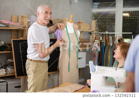 Aged sewing instructor teaching garment modeling using dress form 132592311